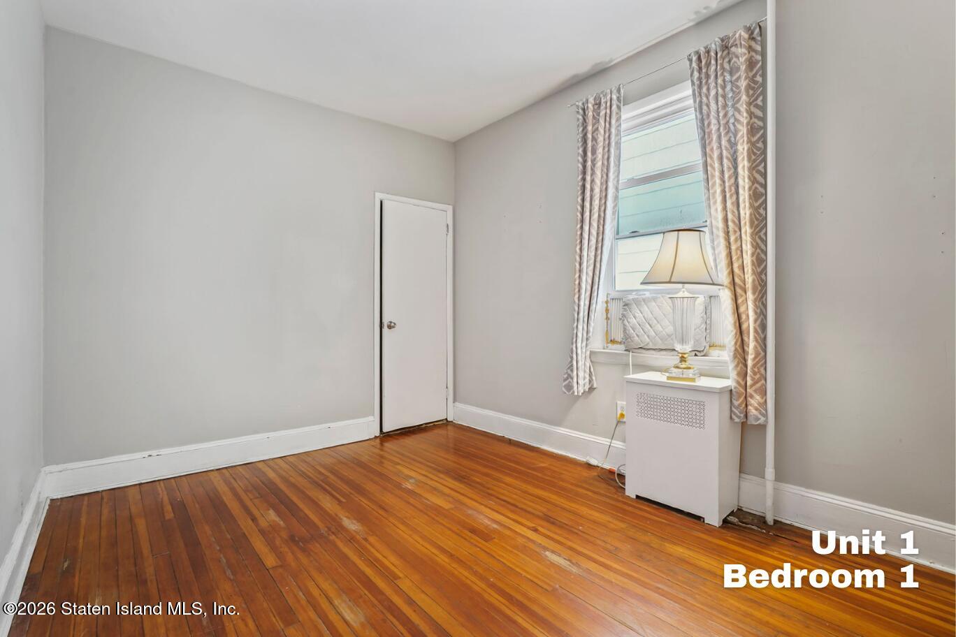 116 Silver Lake Road Staten Island, NY 10301 - Photo 10 of 36 a view of empty room with wooden floor