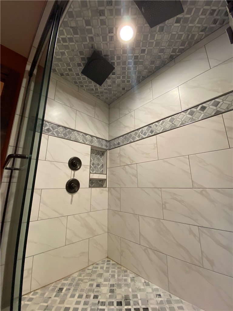 128 McAlister Road West Union, SC 29696 - Photo 29 of 40 A luxuriously tiled shower with mosaic accents and overhead rain shower heads.