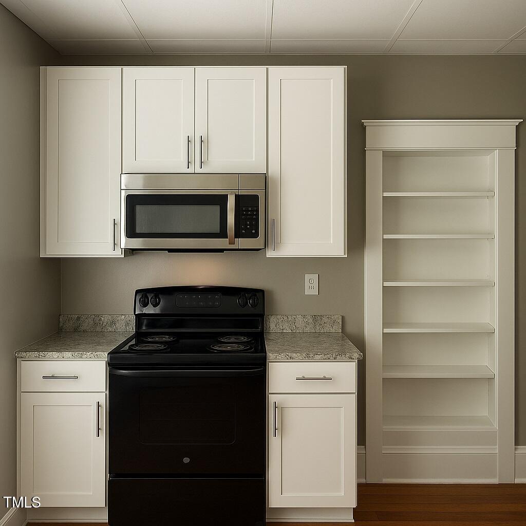 23 Dixie Trail Raleigh, NC 27607 - Photo 5 of 7 a kitchen with a stove microwave and cabinets