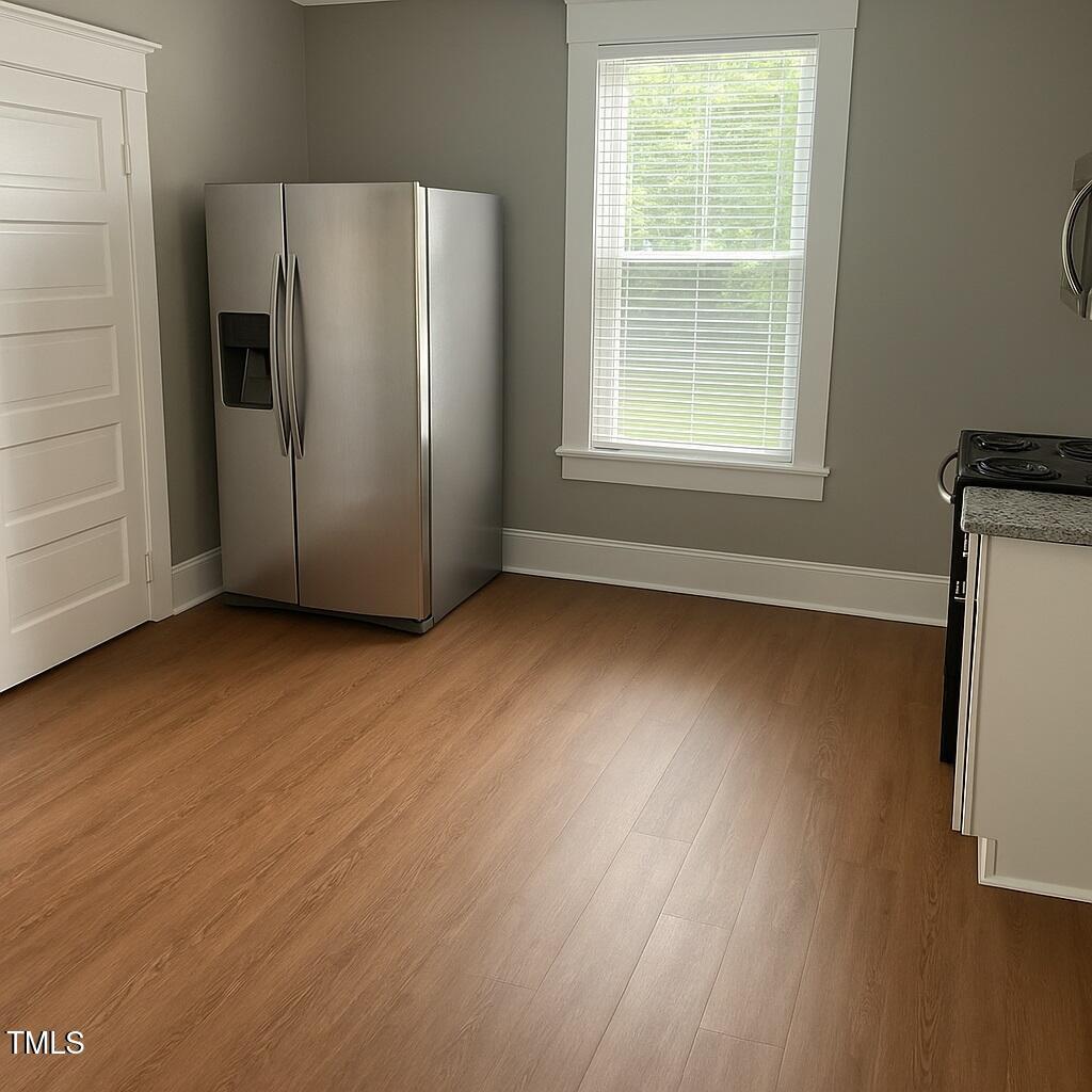 23 Dixie Trail Raleigh, NC 27607 - Photo 6 of 7 an empty room with wooden floor and a window