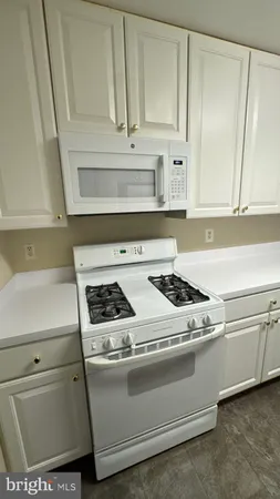 a kitchen with granite countertop a sink and white cabinets