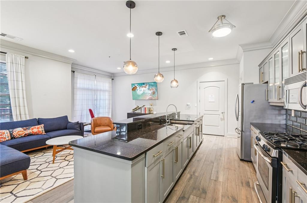 1055 Piedmont Avenue Northeast, Unit 309 Atlanta, GA 30309 - Photo 19 of 23 a kitchen with stainless steel appliances granite countertop a stove a sink island and a refrigerator