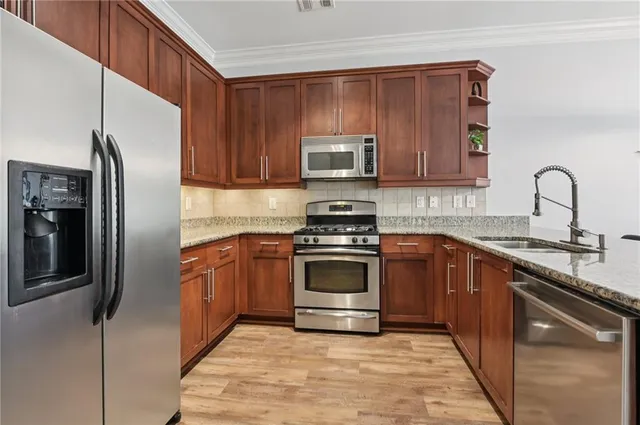 a kitchen with granite countertop a refrigerator stove and microwave