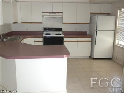 18266 Apple Road Fort Myers, FL 33967 - Photo 4 of 10 a kitchen with kitchen island cabinets and oven