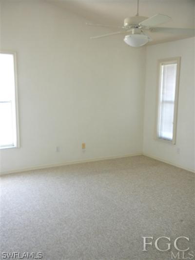 18266 Apple Road Fort Myers, FL 33967 - Photo 5 of 10 an empty room with windows and fan