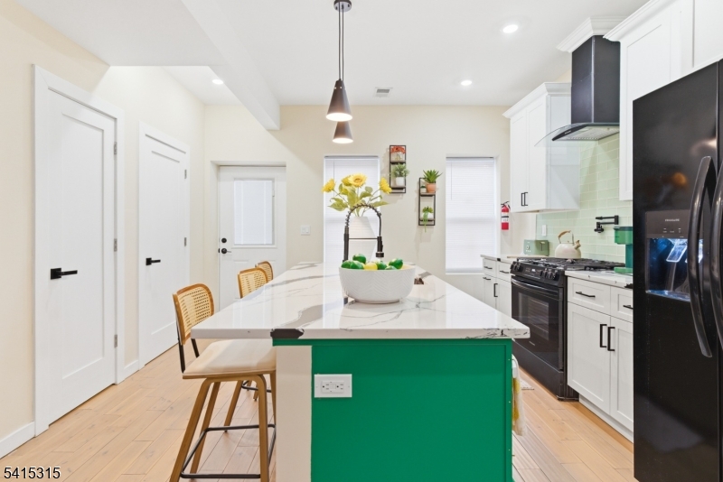 16 Eagles Street Newark, NJ 07102 - Photo 11 of 35 a kitchen with kitchen island stainless steel appliances sink stove dining table and chairs