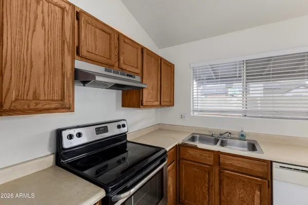 a kitchen with a sink stove top oven and cabinets