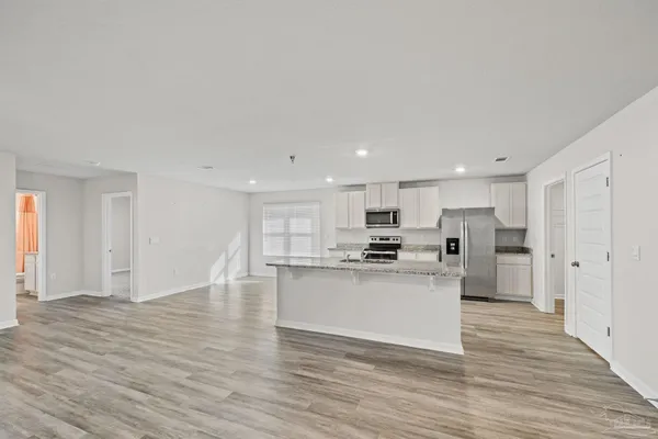 a kitchen with stainless steel appliances granite countertop a sink and refrigerator