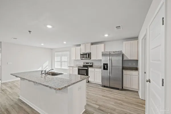 a kitchen with a sink stove and cabinets