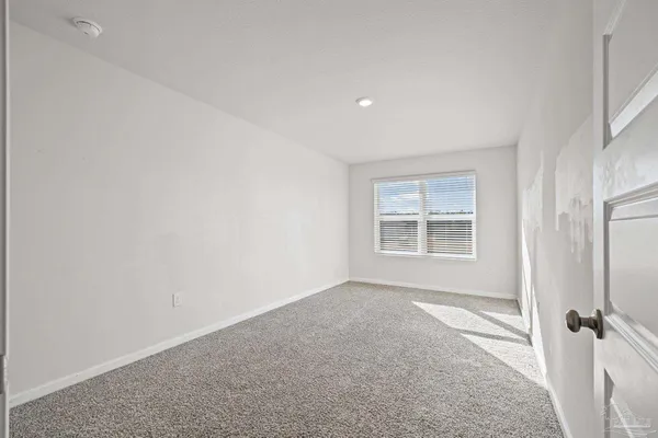 a view of a hallway with wooden floor and a bathroom