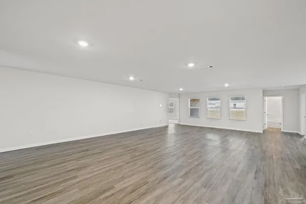 a view of empty room with wooden floor and window