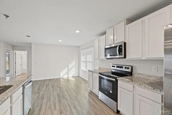 a kitchen with stainless steel appliances a refrigerator and a stove top oven