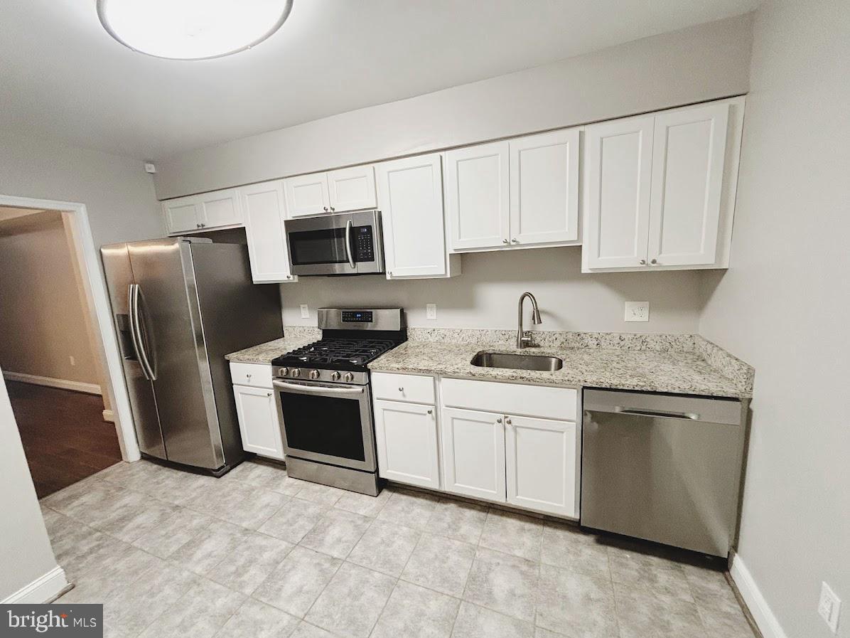 1721 North Bond Street Baltimore, MD 21213 - Photo 5 of 21 a kitchen with stainless steel appliances granite countertop a stove a sink dishwasher a refrigerator and a microwave