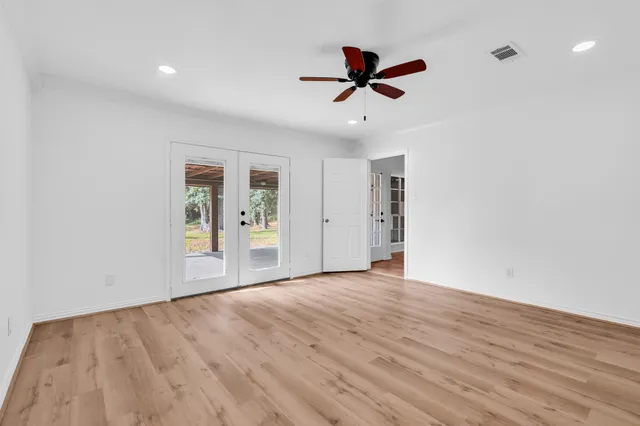 a view of empty room with wooden floor and window