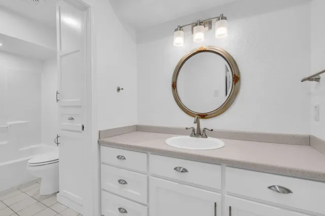 a bathroom with a toilet a sink and a mirror