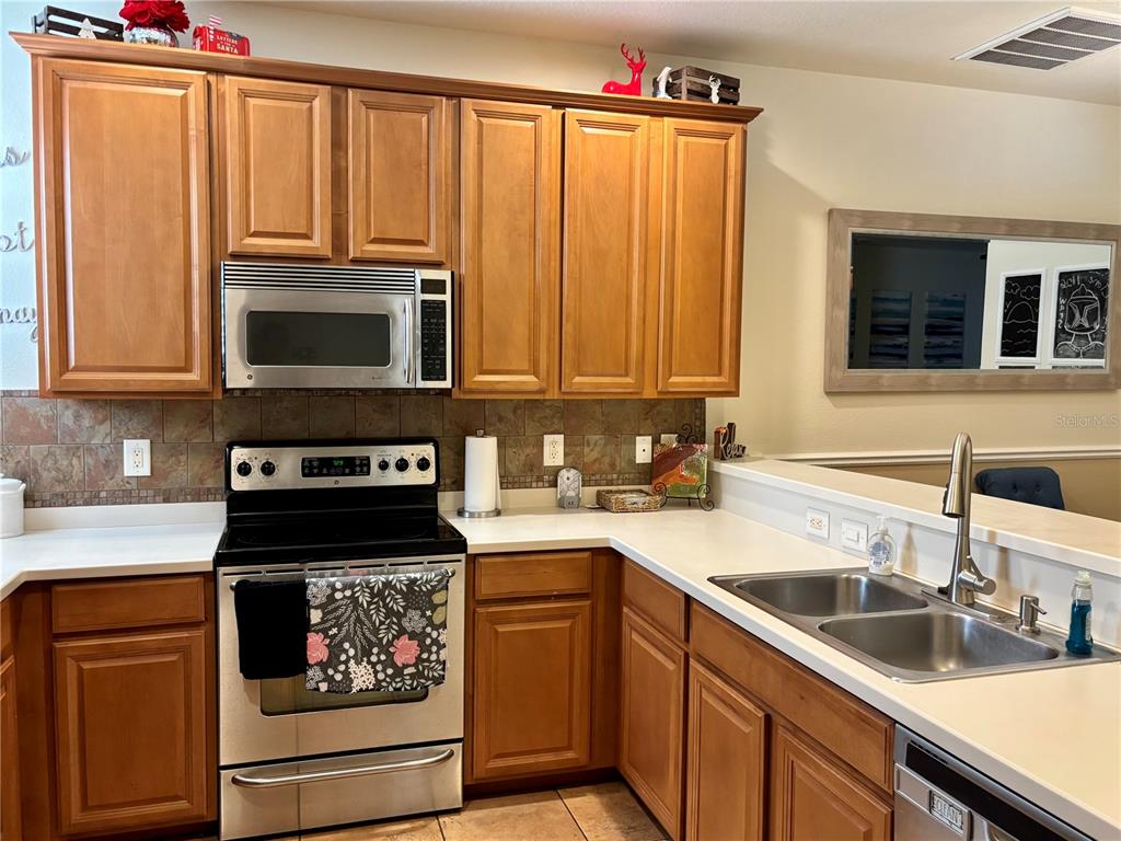 5633 Blackfin Drive New Port Richey, FL 34652 - Photo 21 of 46 a kitchen with granite countertop a stove microwave and sink