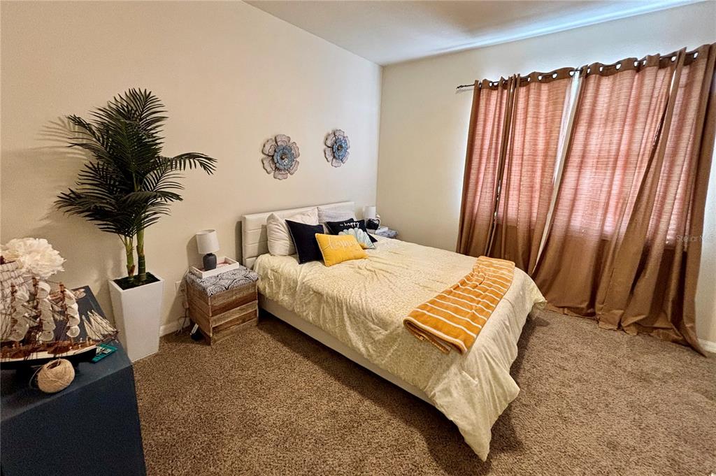 5633 Blackfin Drive New Port Richey, FL 34652 - Photo 22 of 46 a bedroom with a bed and a potted plant