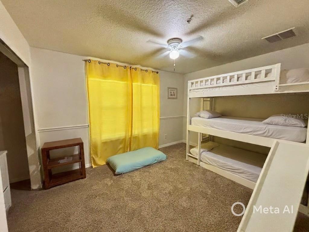 5633 Blackfin Drive New Port Richey, FL 34652 - Photo 29 of 46 a bedroom with a bed and a chandelier