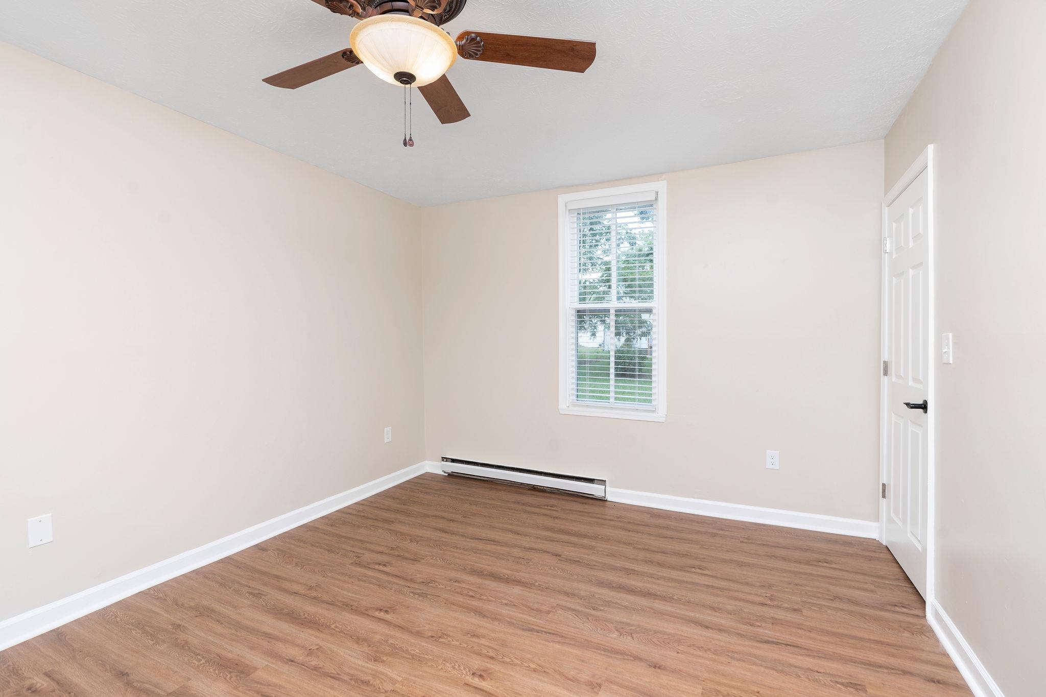 2302 Lee Highway Mount Sidney, VA 24467 - Photo 32 of 75 an empty room with wooden floor chandelier fan and windows