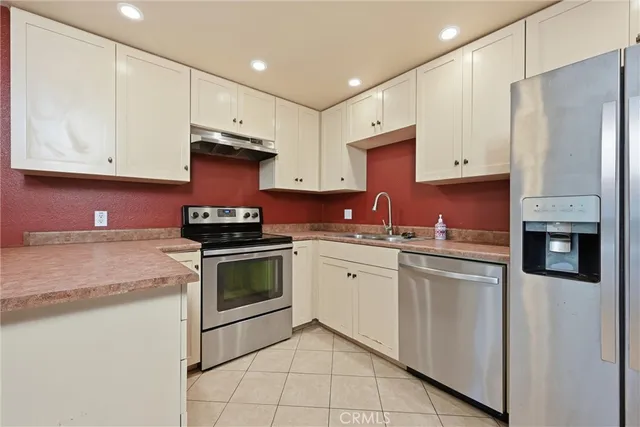 a kitchen with stainless steel appliances granite countertop a stove a sink and a refrigerator
