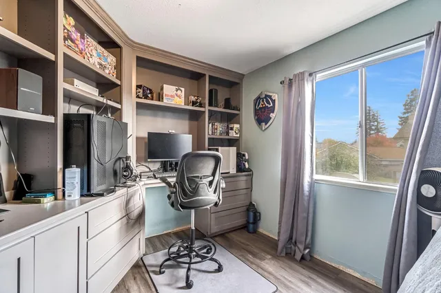 a view of a workspace with furniture and a window