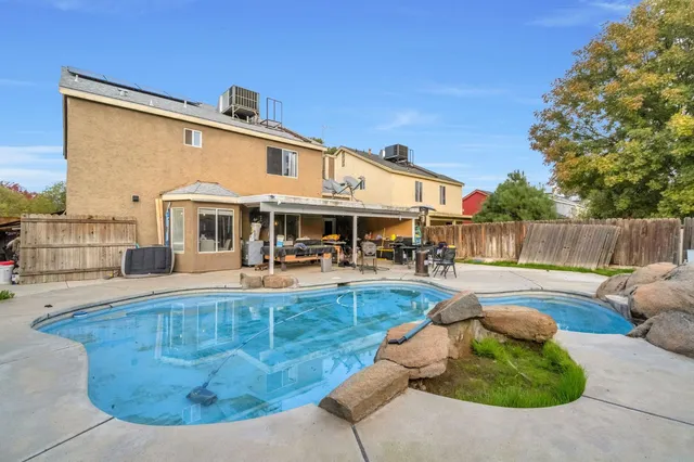 a view of a house with swimming pool and sitting area