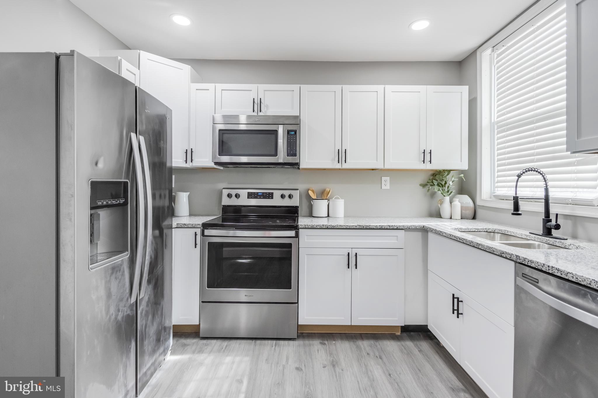 2817 Winchester Street Baltimore, MD 21216 - Photo 19 of 29 a kitchen with stainless steel appliances a sink cabinets and a refrigerator