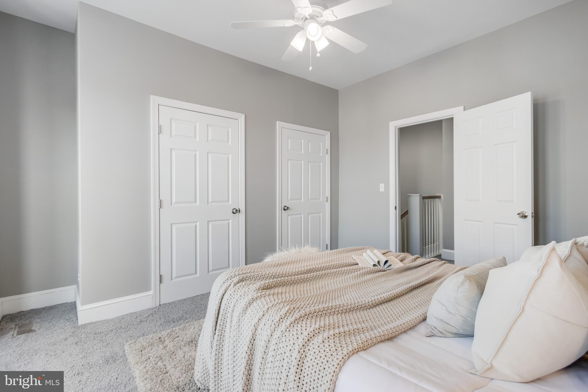 2817 Winchester Street Baltimore, MD 21216 - Photo 20 of 29 a bedroom with a large bed and chandelier fan