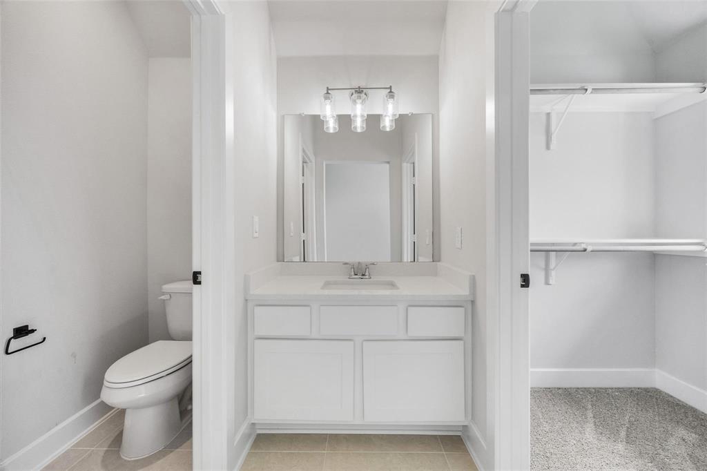 504 Sundance Ridge Georgetown, TX 78628 - Photo 25 of 34 A modern vanity sits between a private toilet area and an organized walk-in closet.