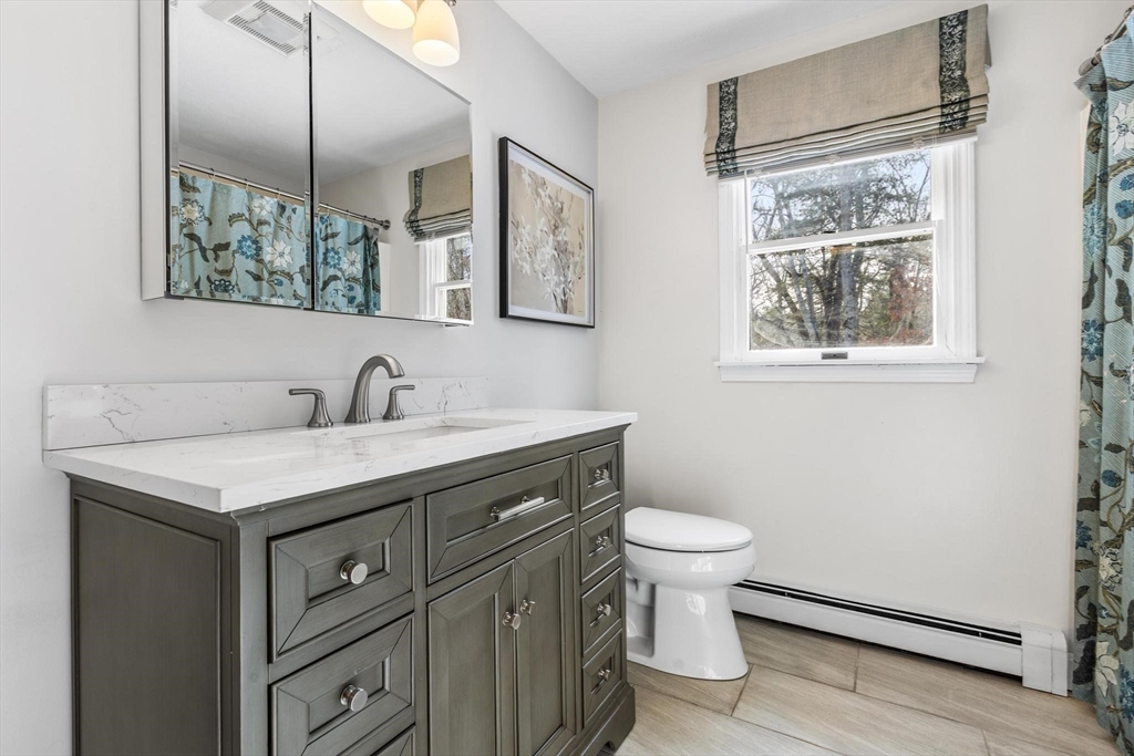 68 Sanborn Lane Reading, MA 01867 - Photo 11 of 42 a bathroom with a granite countertop sink a toilet and a mirror