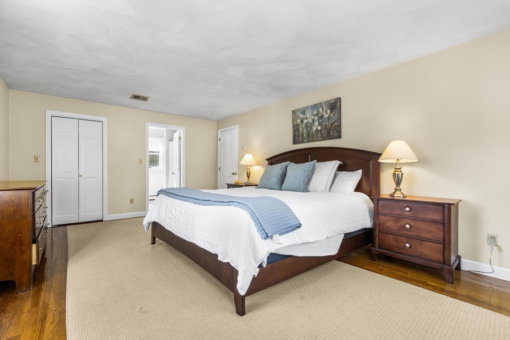 68 Sanborn Lane Reading, MA 01867 - Photo 17 of 42 a spacious bedroom with a bed and a lamp