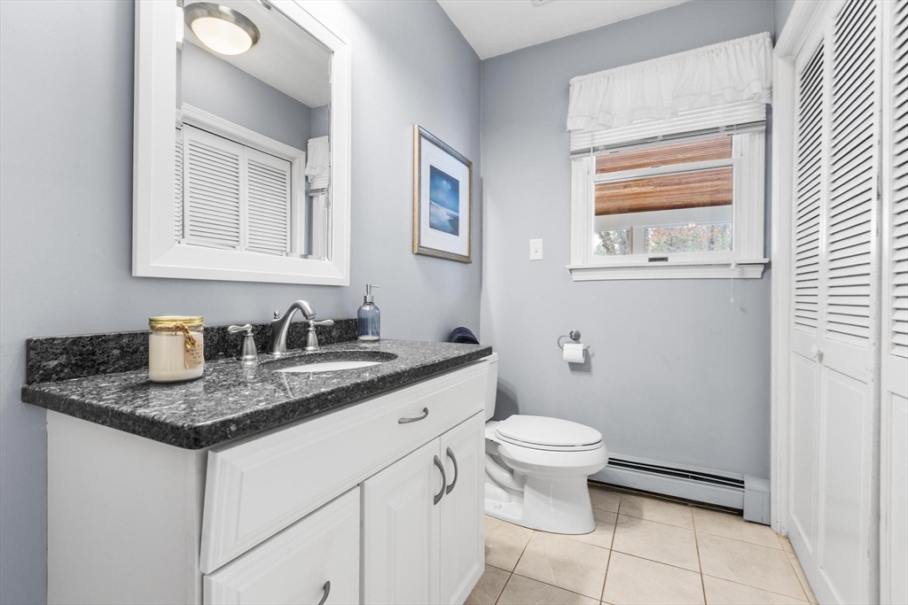 68 Sanborn Lane Reading, MA 01867 - Photo 30 of 42 a bathroom with a granite countertop sink a toilet and a mirror