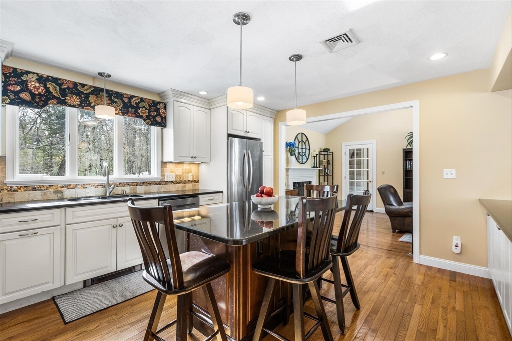 68 Sanborn Lane Reading, MA 01867 - Photo 31 of 42 a view of a dining room and livingroom with furniture wooden floor a chandelier