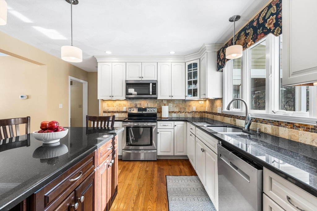 68 Sanborn Lane Reading, MA 01867 - Photo 4 of 42 a kitchen with stainless steel appliances granite countertop a sink and stove