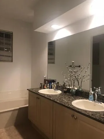 a bathroom with a double vanity sink and a mirror