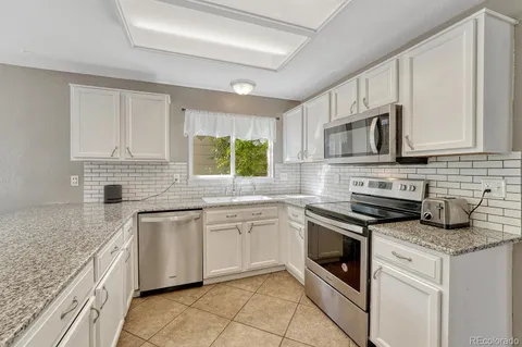 a kitchen with stainless steel appliances granite countertop a sink stove and cabinets