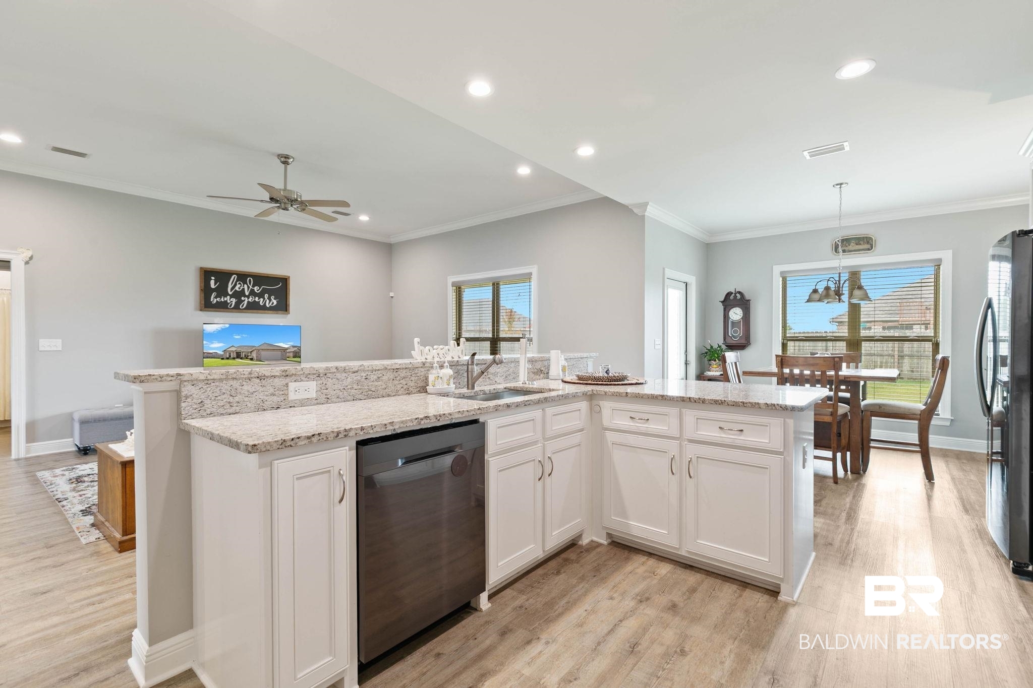 9388 Pembrook Loop Fairhope, AL 36532 - Photo 22 of 53 Kitchen featuring white cabinets, a kitchen island with sink, appliances with stainless steel finishes, light stone countertops, and healthy amount of natural light