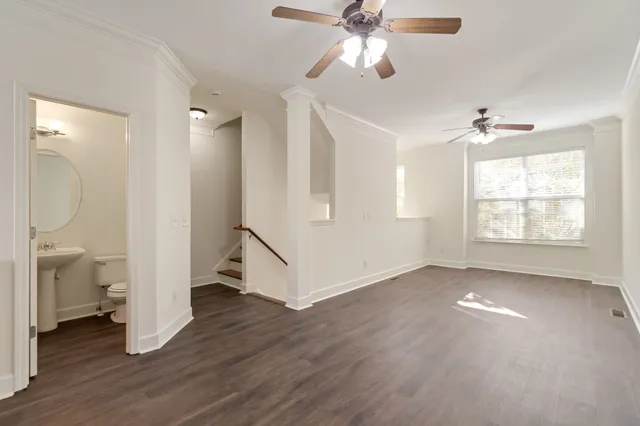 a kitchen with stainless steel appliances granite countertop a stove a sink a refrigerator white cabinets and wooden floor