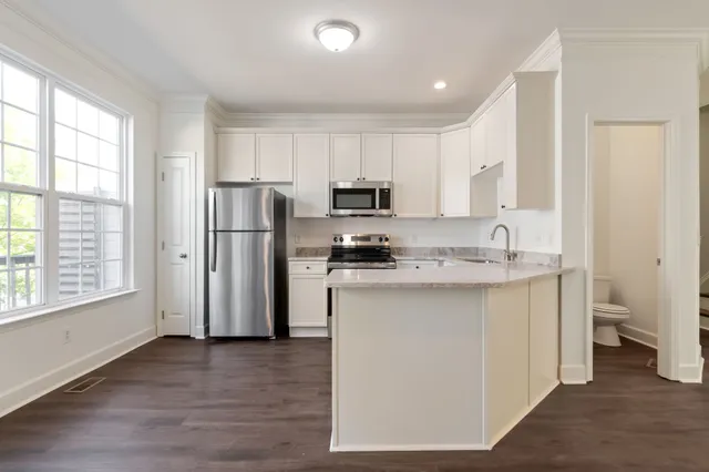 a kitchen with a refrigerator sink and cabinets