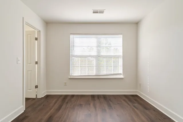 an empty room with wooden floor & closet area
