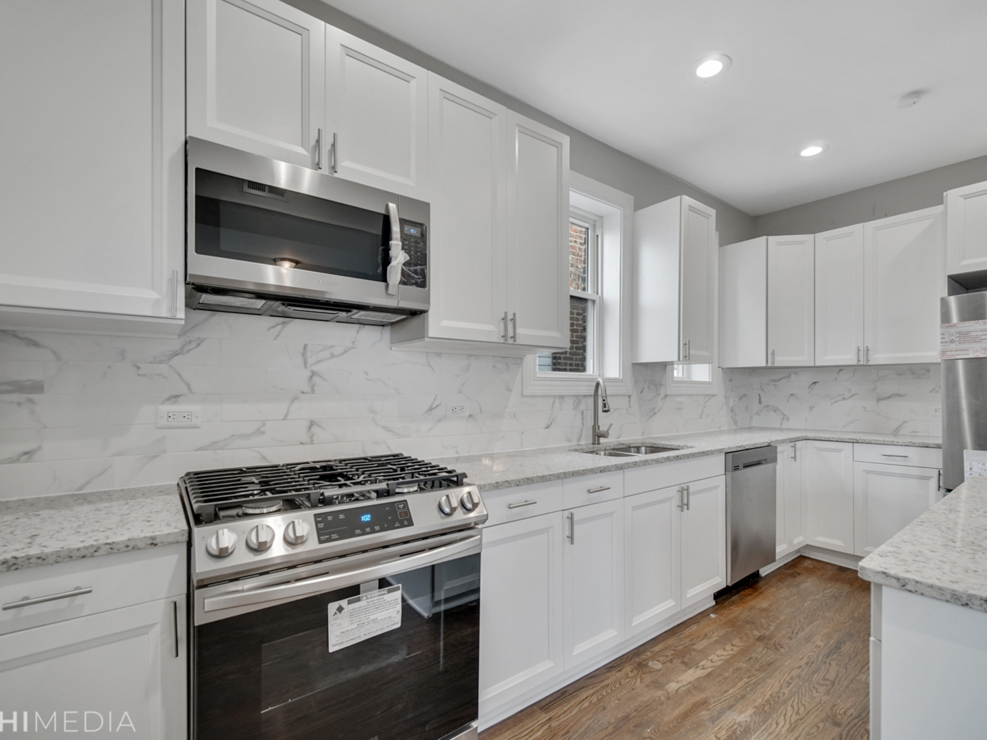 6234 South Rhodes Avenue Chicago, IL 60637 - Photo 15 of 36 a kitchen with stainless steel appliances a sink a stove a microwave and cabinets