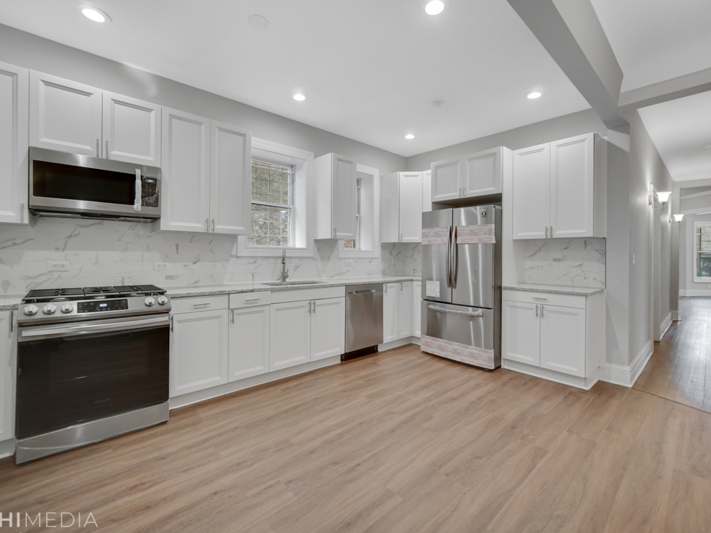 6234 South Rhodes Avenue Chicago, IL 60637 - Photo 16 of 36 a kitchen with stainless steel appliances white cabinets a sink a stove a microwave and cabinetry
