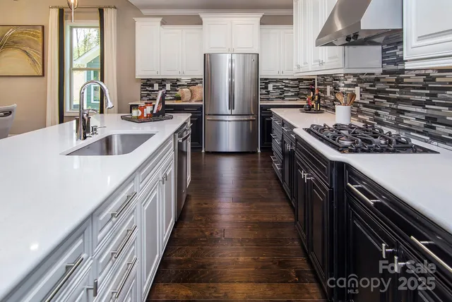 a kitchen with stainless steel appliances granite countertop a sink and a refrigerator