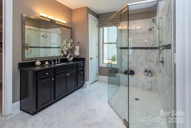 a bathroom with a double vanity sink a mirror and shower