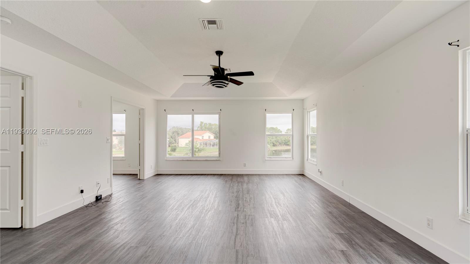 7109 Waldon Pond Stuart, FL 34997 - Photo 16 of 20 an empty room with wooden floor and windows