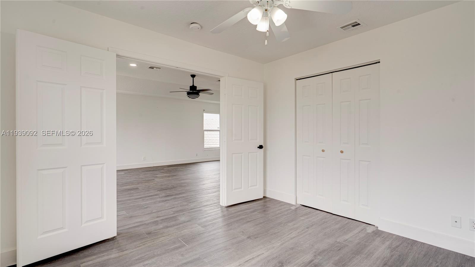 7109 Waldon Pond Stuart, FL 34997 - Photo 17 of 20 an empty room with wooden floor and windows