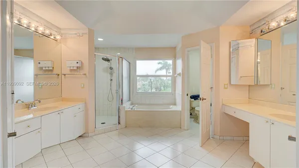 a bathroom with a tub sink shower and mirror