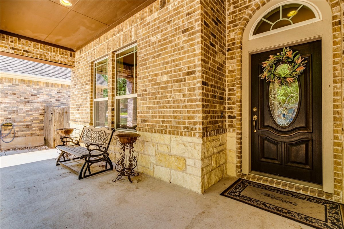 12909 Medina River Way Austin, TX 78732 - Photo 7 of 36 An inviting covered front entry features classic brickwork, and stone accents.