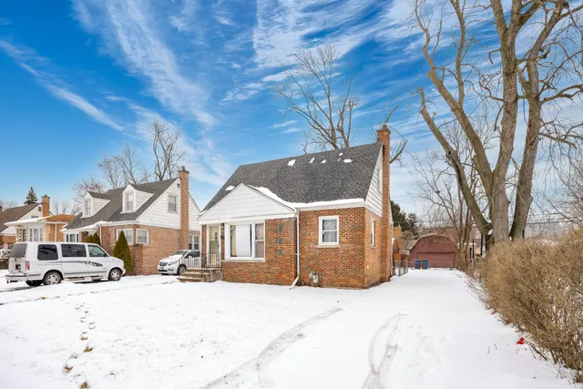 a front view of a house with a yard covered in snow