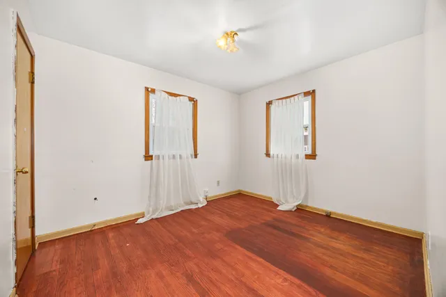 an empty room with a window and a ceiling fan